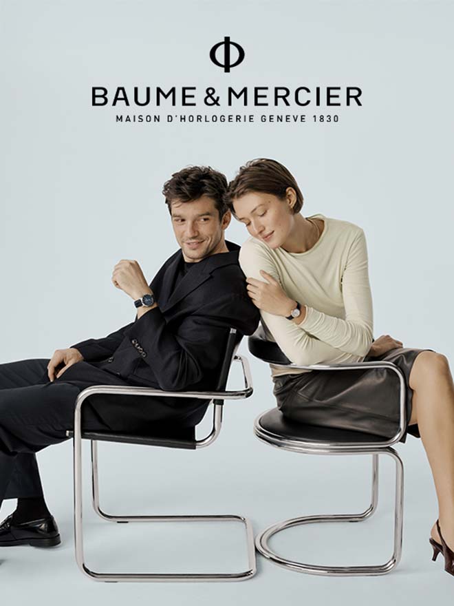 Paar mit Baume & Mercier Uhren und sitzt Rücken an Rücken 