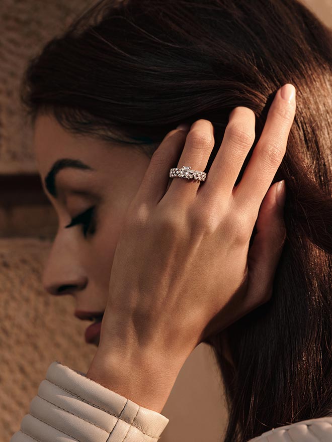 Frau trägt einen Ring von Serafino Consoli Wempe-Cut Solitär und streicht sich eine Haarsträhne hinter das Ohr 