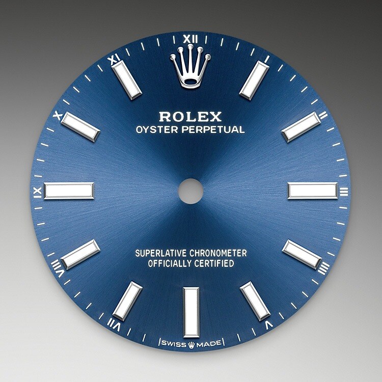 Der Radialschliff lässt zarte Lichtreflexe auf vielen Zifferblättern der Oyster Perpetual Kollektion entstehen. Er umfasst virtuose Bürsttechniken, mit denen Riffelungen erzeugt werden, die von der Mitte des Zifferblatts her ausstrahlen. Licht fließt an jeder Einkerbung entlang und schafft damit einen charakteristischen subtilen Schimmer, der sich mit der Bewegung des Handgelenks verändert. Sobald der Radialschliff abgeschlossen ist, wird die Farbe anhand des PVD-Verfahrens (<i>Physical Vapour Deposition</i>, physikalische Gasphasenabscheidung) oder der Galvanoplastik auf das Zifferblatt aufgetragen. Eine dezente Lackierung verleiht dem Zifferblatt sein vollständiges Erscheinungsbild.