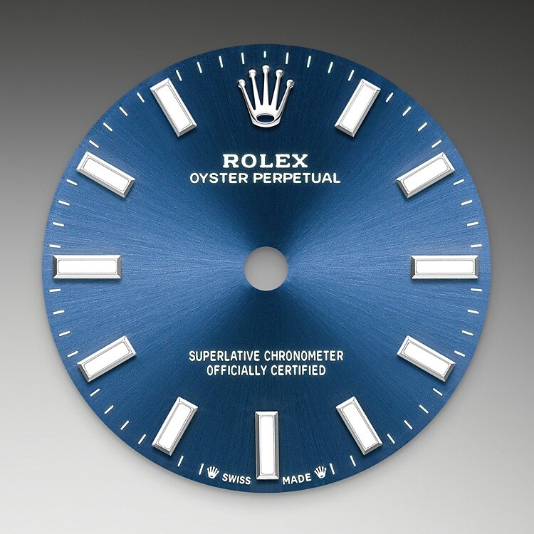Der Radialschliff lässt zarte Lichtreflexe auf vielen Zifferblättern der Oyster Perpetual Kollektion entstehen. Er umfasst virtuose Bürsttechniken, mit denen Riffelungen erzeugt werden, die von der Mitte des Zifferblatts her ausstrahlen. Licht fließt an jeder Einkerbung entlang und schafft damit einen charakteristischen subtilen Schimmer, der sich mit der Bewegung des Handgelenks verändert. Sobald der Radialschliff abgeschlossen ist, wird die Farbe anhand des PVD-Verfahrens (<i>Physical Vapour Deposition</i>, physikalische Gasphasenabscheidung) oder der Galvanoplastik auf das Zifferblatt aufgetragen. Eine dezente Lackierung verleiht dem Zifferblatt sein vollständiges Erscheinungsbild.