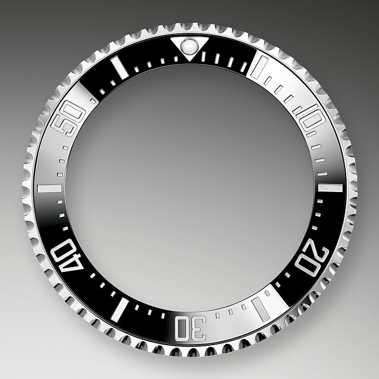 Dank der in eine Richtung drehbaren Lünette mit 60‑Minuten-Graduierung der Rolex Deepsea lassen sich Tauch- und Dekompressionszeiten präzise und sicher ablesen. Sie ist mit einer von Rolex patentierten und hergestellten schwarzen Cerachrom-Zahlenscheibe ausgestattet, die aus äußerst kratzfester und hochbeständiger Keramik besteht. Die Graduierung wird im PVD-Verfahren (PVD = <i>Physical Vapour Deposition</i>, physikalische Gasphasenabscheidung) mit einer feinen Platinschicht überzogen. Das schlicht gehaltene schwarze Zifferblatt präsentiert sich mit breiten Chromalight-Indizes und Chromalight-Zeigern, deren blaugetönte Beschichtung lange nachleuchtet, wodurch beste Ablesbarkeit auch im Dunkeln gewährleistet ist.