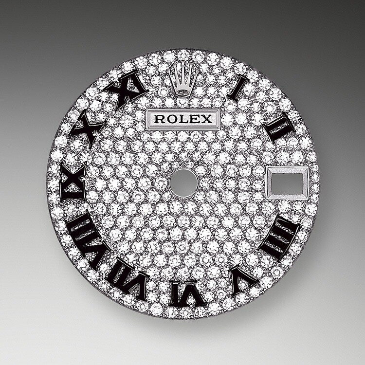 Les cadrans pavés de diamants sont une symphonie pétillante qui sublime la montre et enchante son propriétaire. Les sertisseurs creusent à la main le réceptacle aux dimensions parfaites dans lequel la pierre précieuse viendra s’insérer. En plus de la qualité intrinsèque des pierres, d’autres critères entrent en jeu et entretiennent la réputation du sertissage Rolex : l’alignement précis de la hauteur des pierres, leur orientation et leur position, leur robustesse, la régularité et l’esthétique du sertissage ainsi que la finition du travail sur le métal.