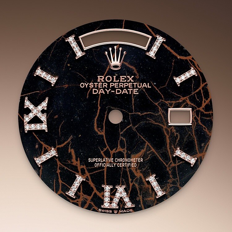 This dial features hour markers in 18 ct gold, set with 32 diamonds, and a Roman VI and IX in 18 ct gold, set with 24 diamonds. The Oyster Perpetual Day-Date 36 is presented with a dial made from eisenkiesel, a deep brown decorative stone used by the brand for the first time in 2021. Eisenkiesel is an iron-oxide, delicately veined quartz. The stone discs destined for the dials are cut from a block of raw material. Only those whose colour and structure fully satisfy the brand’s exacting aesthetic requirements are selected. They will grace the dial of a Rolex watch, conferring it with a unique personality.