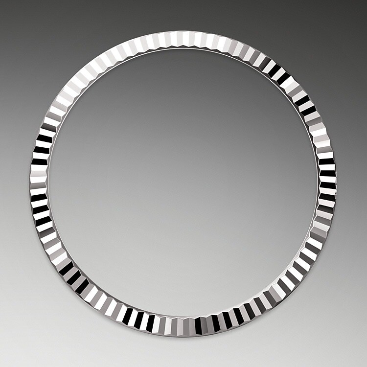 Die geriffelte Lünette von Rolex ist ein Markenzeichen. Ursprünglich hatte die Riffelung der Oyster Lünette einen praktischen Zweck: Sie diente zum Verschrauben mit dem Gehäuse, um die Wasserdichtheit der Armbanduhr zu gewährleisten. Die Riffelung entsprach deshalb der des Gehäusebodens, der ebenfalls mithilfe von Rolex Spezialwerkzeugen mit dem Gehäuse verschraubt wurde, um die Uhr wasserdicht zu machen. Mit der Zeit erhielt die Riffelung eine rein ästhetische Funktion und wurde zu einem prägenden Element des stilistischen Markenerbes von Rolex. Heute ist die geriffelte Lünette ein Distinktionsmerkmal, das bei dieser Datejust 36 in Gold gefertigt wird.
