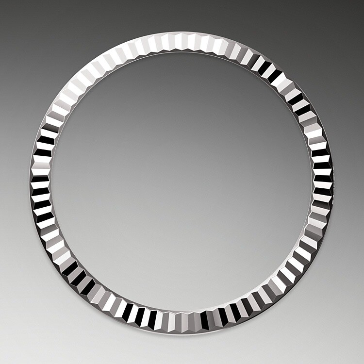 La lunette cannelée est l’élément signature de Rolex. Au départ, les cannelures de la lunette Oyster avaient un but fonctionnel : elles servaient à visser la lunette sur le boîtier, de manière à garantir l’étanchéité de la montre. De plus, elles étaient identiques aux cannelures présentes sur le fond de boîtier, lui aussi vissé sur le boîtier pour la même raison, au moyen d’outils Rolex spécifiques. Avec le temps, les cannelures sont devenues un élément purement esthétique, la signature de Rolex. Aujourd'hui la lunette cannelée est un élément signature, en or sur cette Datejust 31.