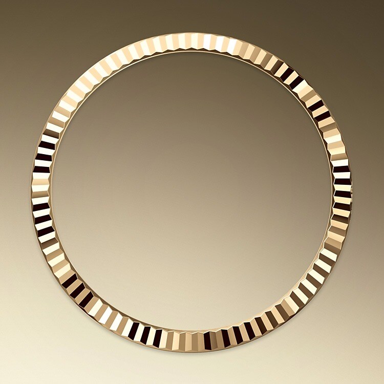 The Rolex fluted bezel is a mark of distinction. Originally, the fluting of the Oyster bezel had a functional purpose: it served to screw the bezel onto the case helping to ensure the waterproofness of the watch. It was therefore identical to the fluting on the case back, which was also screwed onto the case for waterproofness, using specific Rolex tools. Over time, the fluting became an aesthetic element, a genuine Rolex signature feature. Today the fluted bezel is a mark of distinction, in gold on this Day-Date 36.