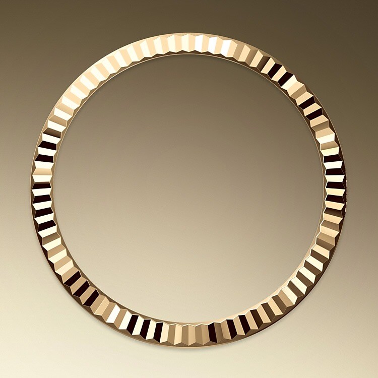 The Rolex fluted bezel is a mark of distinction. Originally, the fluting of the Oyster bezel had a functional purpose: it served to screw the bezel onto the case helping to ensure the waterproofness of the watch. It was therefore identical to the fluting on the case back, which was also screwed onto the case for waterproofness, using specific Rolex tools. Over time, the fluting became an aesthetic element, a genuine Rolex signature feature. Today the fluted bezel is a mark of distinction, in gold on this Datejust 31.