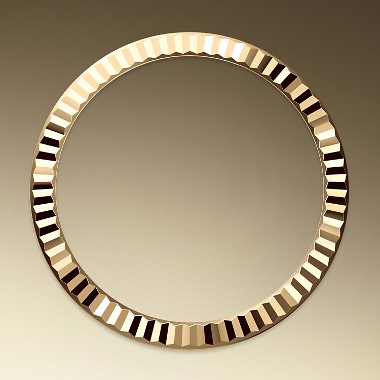 The Rolex fluted bezel is a mark of distinction. Originally, the fluting of the Oyster bezel had a functional purpose: it served to screw the bezel onto the case helping to ensure the waterproofness of the watch. It was therefore identical to the fluting on the case back, which was also screwed onto the case for waterproofness, using specific Rolex tools. Over time, the fluting became an aesthetic element, a genuine Rolex signature feature. Today the fluted bezel is a mark of distinction, in gold on this Lady-Datejust.