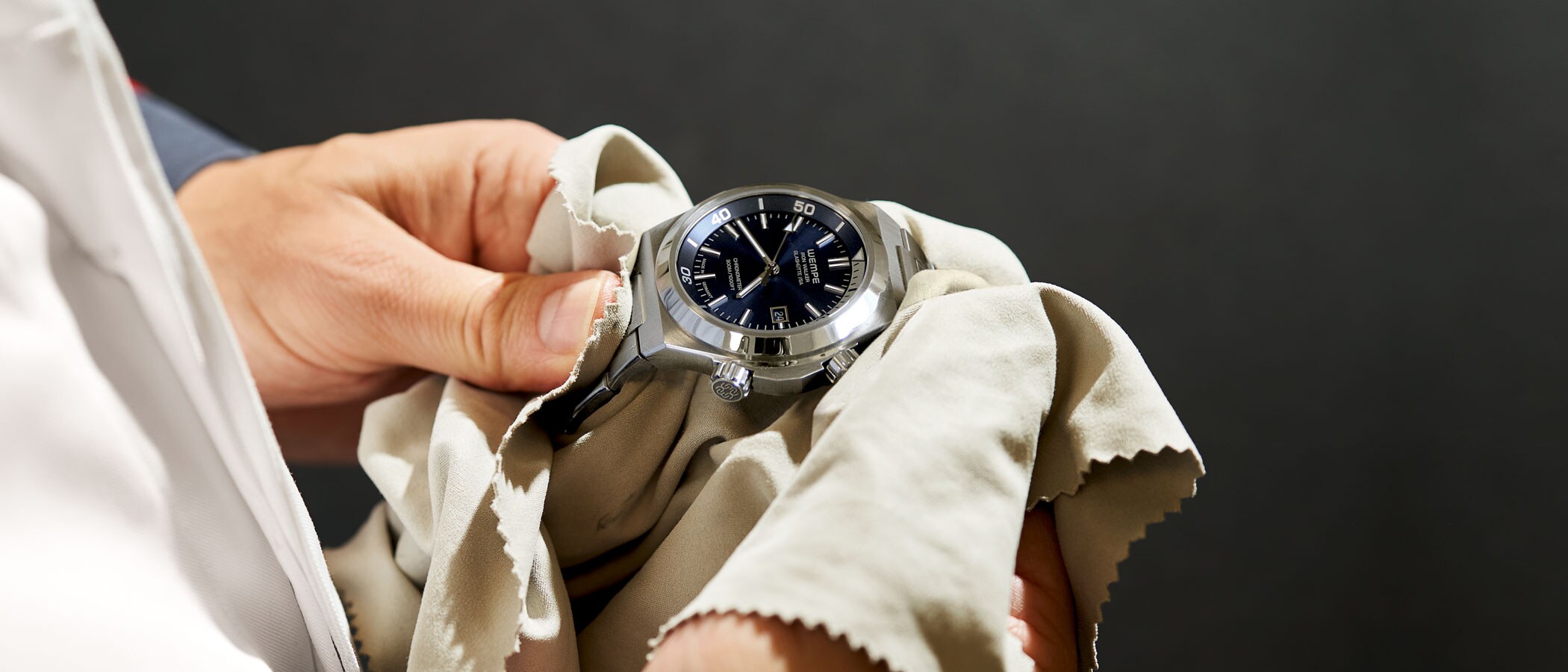 Two hands polishing a watch