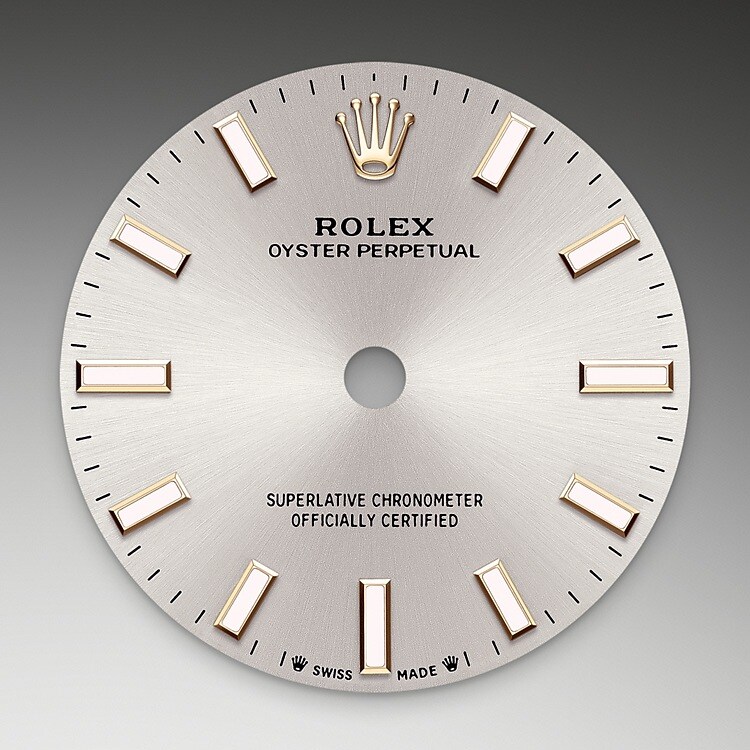 Der Radialschliff lässt zarte Lichtreflexe auf vielen Zifferblättern der Oyster Perpetual Kollektion entstehen. Er umfasst virtuose Bürsttechniken, mit denen Riffelungen erzeugt werden, die von der Mitte des Zifferblatts her ausstrahlen. Licht fließt an jeder Einkerbung entlang und schafft damit einen charakteristischen subtilen Schimmer, der sich mit der Bewegung des Handgelenks verändert. Sobald der Radialschliff abgeschlossen ist, wird die Farbe anhand des PVD-Verfahrens (<i>Physical Vapour Deposition</i>, physikalische Gasphasenabscheidung) oder der Galvanoplastik auf das Zifferblatt aufgetragen. Eine dezente Lackierung verleiht dem Zifferblatt sein vollständiges Erscheinungsbild.