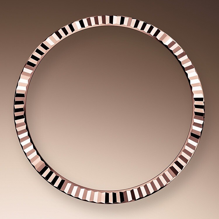 The Rolex fluted bezel is a mark of distinction. Originally, the fluting of the Oyster bezel had a functional purpose: it served to screw the bezel onto the case helping to ensure the waterproofness of the watch. It was therefore identical to the fluting on the case back, which was also screwed onto the case for waterproofness, using specific Rolex tools. Over time, the fluting became an aesthetic element, a genuine Rolex signature feature. Today the fluted bezel is a mark of distinction, in gold on this Datejust 36.
