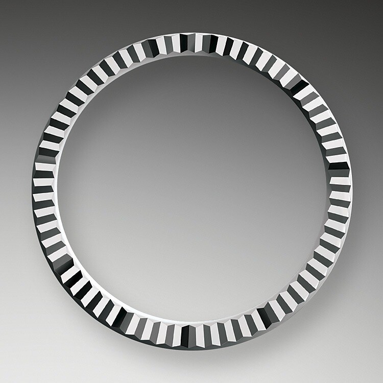 La lunette cannelée est l’élément signature de Rolex. Au départ, les cannelures de la lunette Oyster avaient un but fonctionnel : elles servaient à visser la lunette sur le boîtier, de manière à garantir l’étanchéité de la montre. De plus, elles étaient identiques aux cannelures présentes sur le fond de boîtier, lui aussi vissé sur le boîtier pour la même raison, au moyen d’outils Rolex spécifiques. Avec le temps, les cannelures sont devenues un élément purement esthétique, la signature de Rolex. Aujourd'hui la lunette cannelée est un élément signature, en or sur cette Lady‑Datejust.