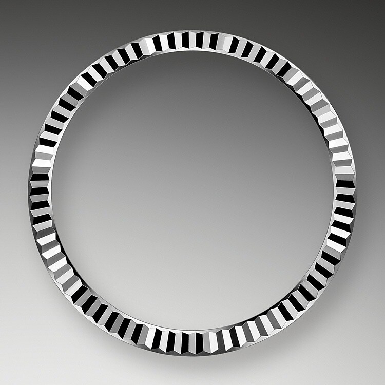 The Rolex fluted bezel is a mark of distinction. Originally, the fluting of the Oyster bezel had a functional purpose: it served to screw the bezel onto the case helping to ensure the waterproofness of the watch. It was therefore identical to the fluting on the case back, which was also screwed onto the case for waterproofness, using specific Rolex tools. Over time, the fluting became an aesthetic element, a genuine Rolex signature feature. Today the fluted bezel is a mark of distinction, in gold on this Datejust 31.