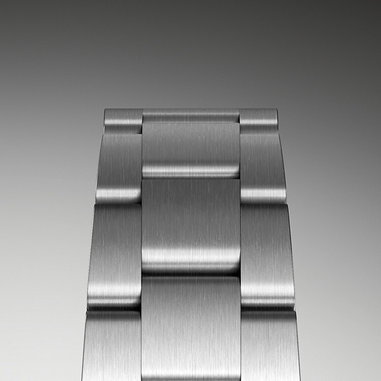Das Oyster-Band ist das Ergebnis einer perfekten Kombination von Form und Funktion, Ästhetik und Technologie. Dieses Ende der 1930er-Jahre eingeführte, besonders robuste und bequeme dreireihige Metallarmband ist mit seinen breiten, flachen Bandelementen nach wie vor das verbreitetste Armband der Oyster Kollektion. Bei den Oyster Perpetual Modellen ist das Oyster-Band mit einer Oysterclasp-Schließe ausgestattet.