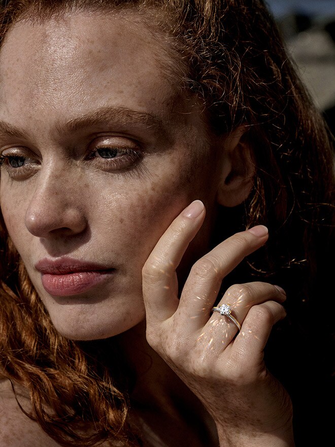 Woman with red curls wearing an Atelier Wempe 137 ring