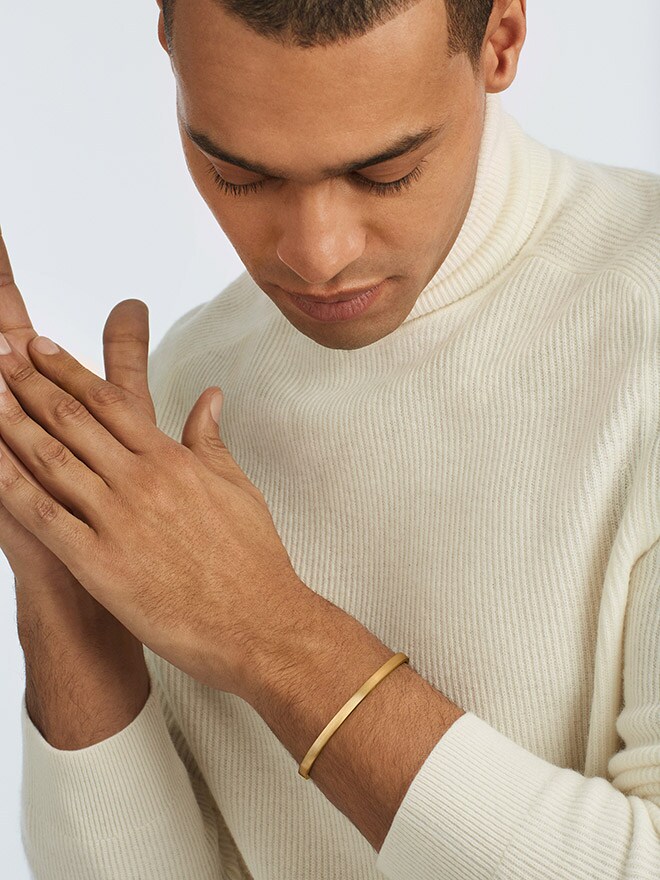 Man in cream-colored sweater wearing flix.flex bangle by Fagnoul
