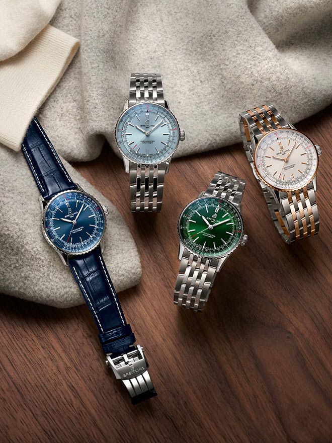 Breitling Navitimer models on a wooden table with clothes