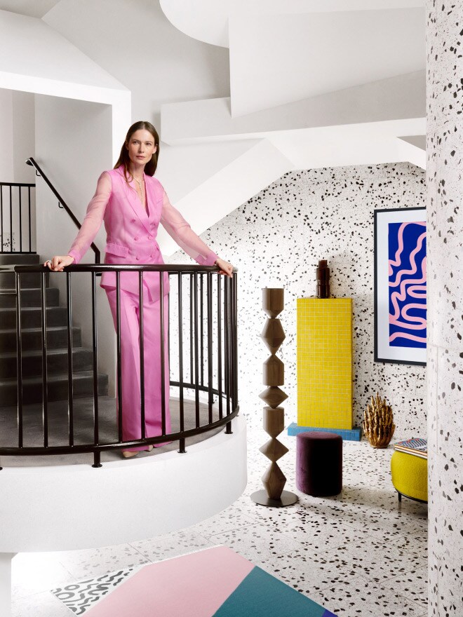 Frau steht in einem bunt dekorierten Raum auf einer Treppe