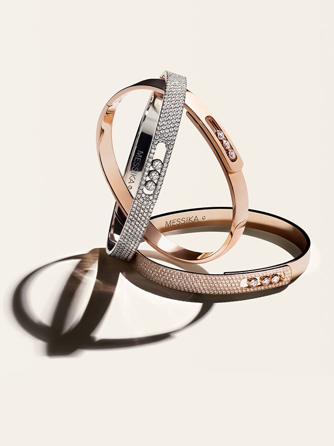 Three bracelets from the Move line on a beige background